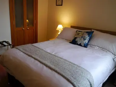 a large white bed with a blue pillow on it at Number 48 in Dumfries