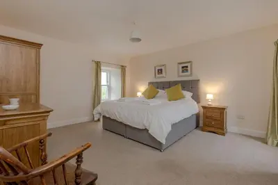 a bedroom with a bed and a desk and a chair at Pant Farmhouse in Ayr