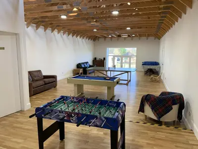 a room with a ping pong table in the middle at Pant Farmhouse in Ayr