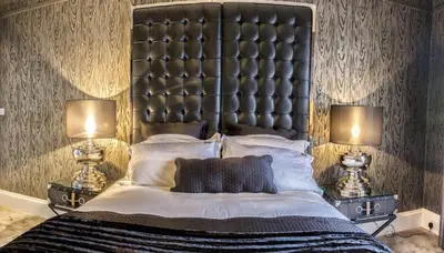 a bedroom with a large bed with two lamps at Ram Lodge in Moffat