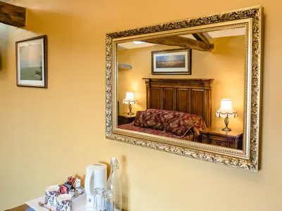 a mirror on the wall of a bedroom at The Wayside and Whisky Barn in Whitbeck
