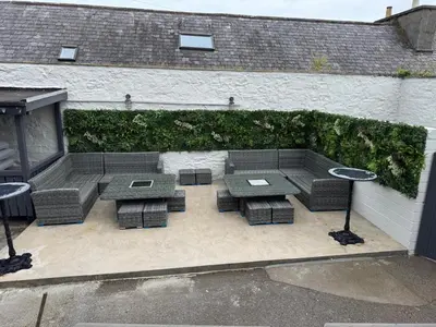 a patio with a table and chairs and a hedge at The Royal Hotel in Stranraer