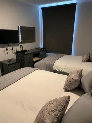 a hotel room with two beds and a desk at The Royal Hotel in Stranraer
