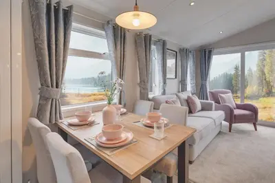 a living room with a table and a couch at Platinum Holiday Caravan in Bothel