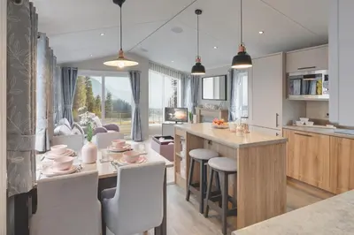 a kitchen and dining room with a table and chairs at Platinum Holiday Caravan in Bothel