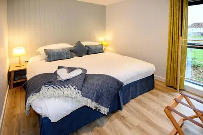 a bedroom with a large bed and a window at The Salt Lodge in Troon