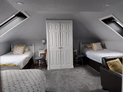 a attic room with two beds and a door at Langside Bed and Breakfast in Fenwick