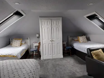 a attic room with two beds and a door at Langside Bed and Breakfast in Fenwick