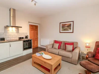 a living room with a couch and a table at Berrymoor Cottage in Brampton