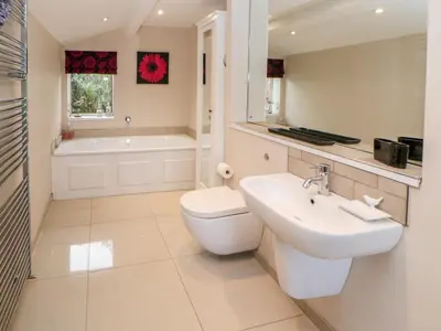 a bathroom with a sink and a toilet and a tub at Berrymoor Cottage in Brampton