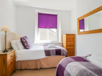 a bedroom with two beds and a window at Sefton House in Keswick