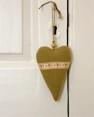 a heart shaped door tag hanging on a white door at 57 High Street in Kirkcudbright