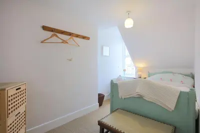 a small bedroom with a bed and a chair at 57 High Street in Kirkcudbright