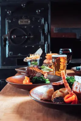 two plates of food on a wooden table at The White Horse Inn Bunkhouse in Threlkeld