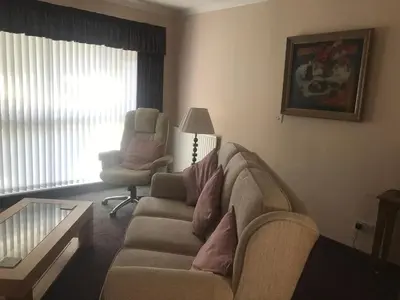 a living room with a couch and a chair at The Clan Macfarlane Apartment in Kilmarnock