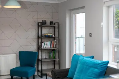 a living room with a couch and a chair at Iona Residence - Donnini Apartments in Ayr