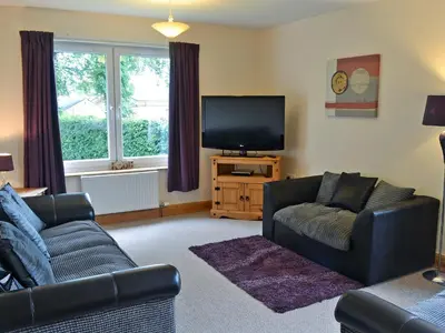 a living room with two couches and a flat screen tv at Cressfield Villa in Ecclefechan