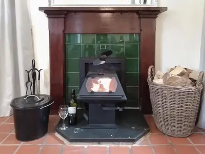 a fireplace in a room with a trash can at The Smiddy in Glasserton