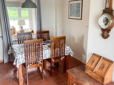 a dining room with a table and four chairs at The Smiddy in Glasserton