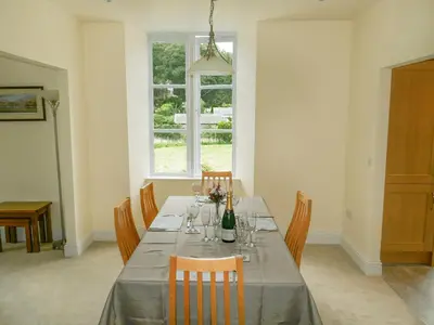 a dining room with a table with a bottle of wine at Easedale Corner in Grasmere