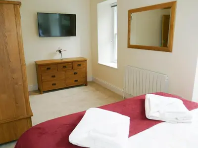 a bedroom with a bed and a mirror and a dresser at Easedale Corner in Grasmere