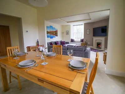 a dining room table with plates and wine glasses at Easedale Corner in Grasmere