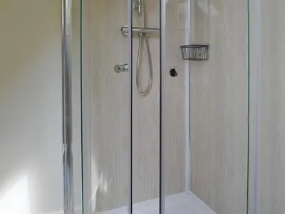 a shower with a glass door in a bathroom at The Brewers Cottage in Mauchline
