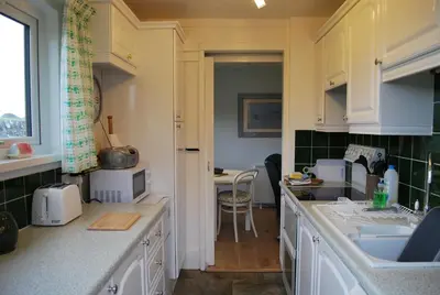 a kitchen with white cabinets and a counter top at 31 Laigh Isle in Isle of Whithorn