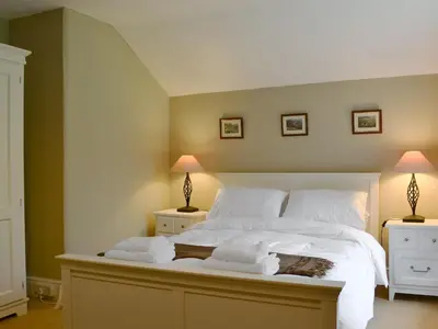 a bedroom with a large white bed with two lamps at Trevene in Buttermere