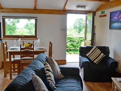 a living room with a blue couch and a table at Pheasant Cottage - Ukc3428 in Dalston