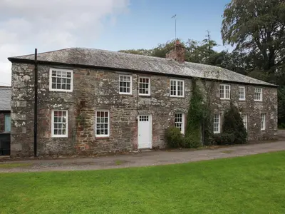 an old stone house with a white door at Orchard Cottage - Uk12525 in Garlieston