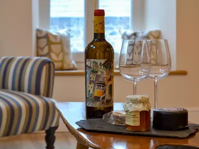 a bottle of wine and two glasses on a table at The Hayloft in Caldbeck