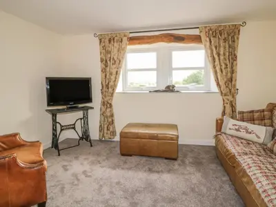 a living room with a couch and a tv at The Barn in Workington