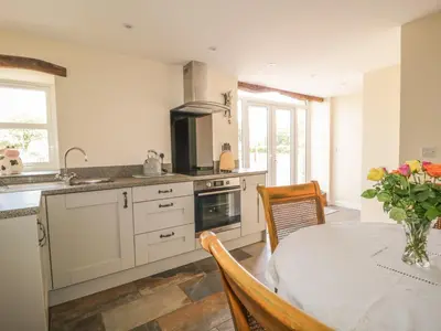 a kitchen with a table and a dining room at The Barn in Workington