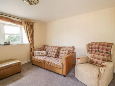 a living room with a couch and a chair at The Barn in Workington