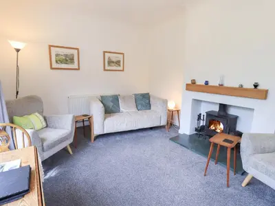 a living room with two couches and a fireplace at Rock Cottage in Keswick