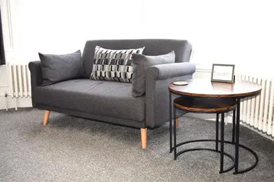 a living room with a couch and a table at Woodlyn Guest House in Gatehouse of Fleet