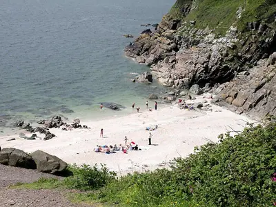 a group of people on a beach near the ocean at Woodlyn Guest House in Gatehouse of Fleet
