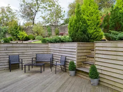 a patio with two chairs and a table and a fence at Kingswood in Whitehaven
