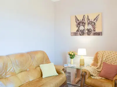 a living room with a couch and a table at Ardlochan Cottage in Maidens