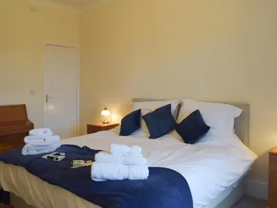 a bedroom with a bed with towels on it at Ardlochan Cottage in Maidens
