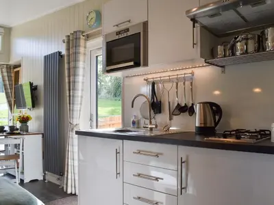 a kitchen with white cabinets and a counter top at Lapwing in Westward