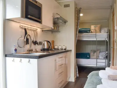 a small kitchen with a sink and a bunk bed at Lapwing in Westward