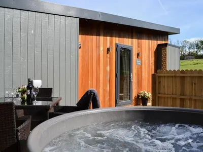 a large hot tub on a patio with a table at Lapwing in Westward
