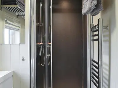 a stainless steel refrigerator in a kitchen at Merlin's Cabin in Westward