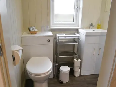 a small bathroom with a toilet and a sink at Merlin's Cabin in Westward