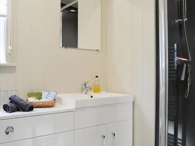 a white bathroom with a sink and a mirror at Curlew in Westward