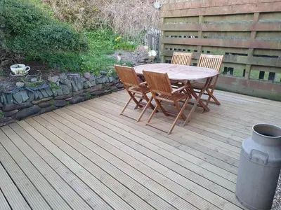 a wooden table and chairs on a wooden deck at Mona Villa Holiday Home in Coulderton