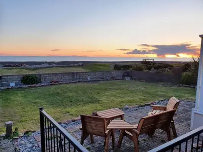 two chairs and a table on a balcony with the ocean at Mona Villa Holiday Home in Coulderton