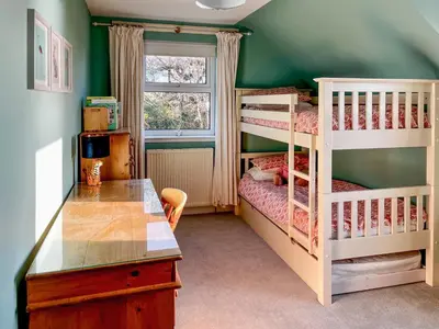 a bedroom with two bunk beds and a window at Saffron in Portpatrick